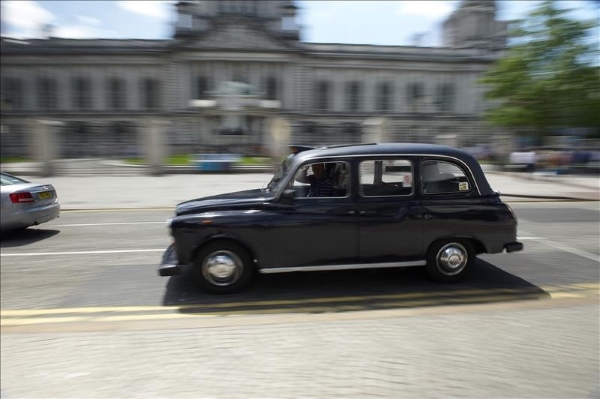 A black taxi outside City Hall in Belfast on a Taxi through the Troubles tour