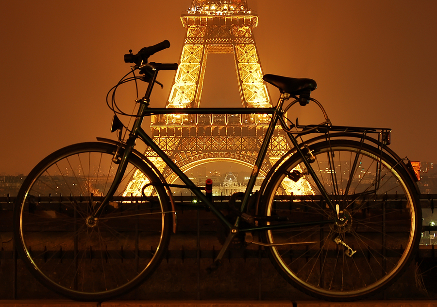 Eiffel tower at night and a bicycle in front of it in Paris