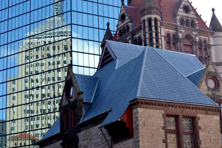 Old buildings reflected in the glass of skyscrapers in Boston