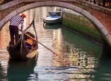 A gondolier going under a bridge in Venice