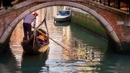 A gondolier going under a bridge in Venice